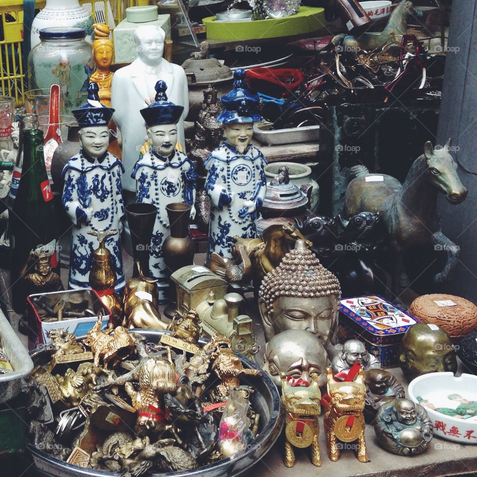 Antiques and knick knacks for sale, displayed on a table along a street in Hong Kong.