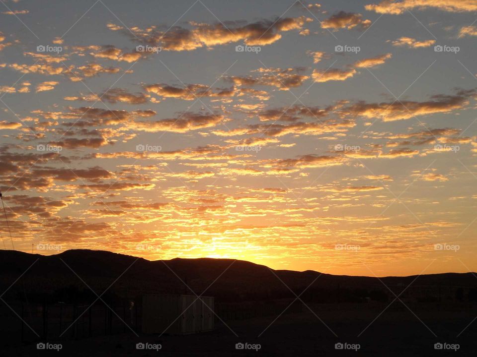 a beautiful sunrise in Fort Irwin, CA with clouds cascading across the sky