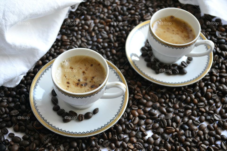 Two Cup of coffee on roasted beans