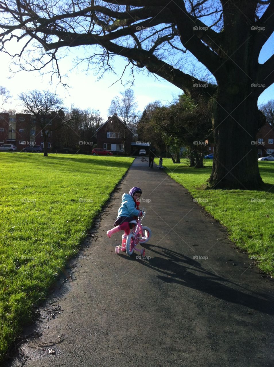 Little girl playing with bicycle in park
