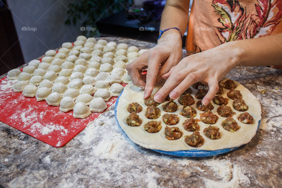 Women making meat dumplings in plate