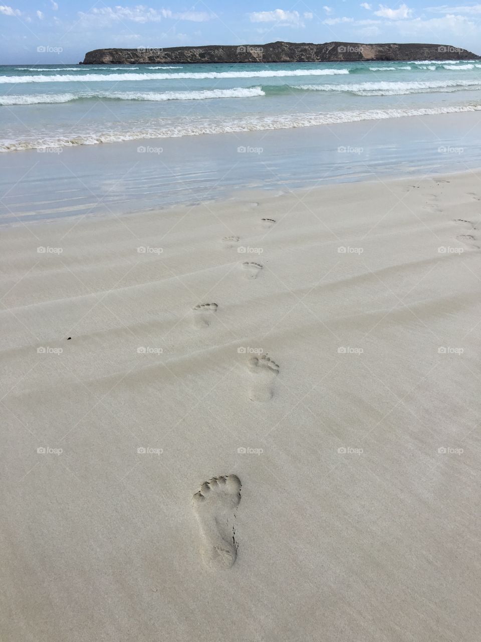 Footprints in white sand on beach leading to the sea, ocean horizon, tropical, journey, destiny