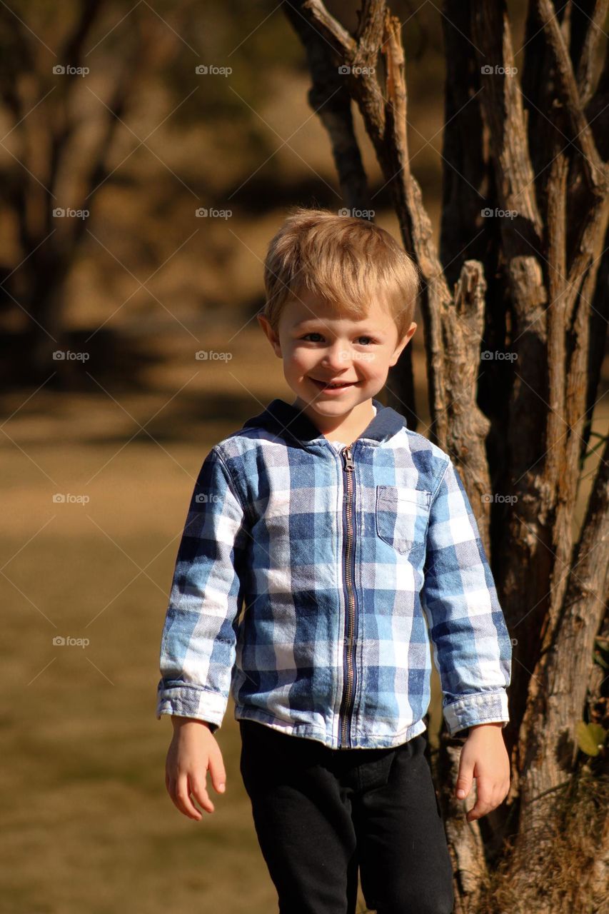 Happy little boy smiling at the park in fall 