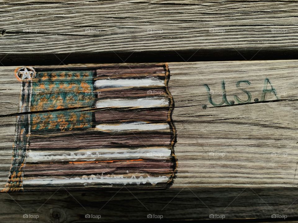 Someone carved these designs in a wooden picnic table. Carving is the act of fashioning or producing by cutting into or shaping solid material, as wood. a carved design or figure.
