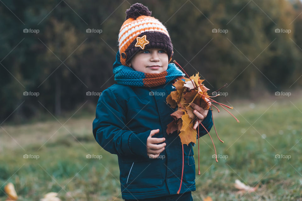 boy plays with leaves