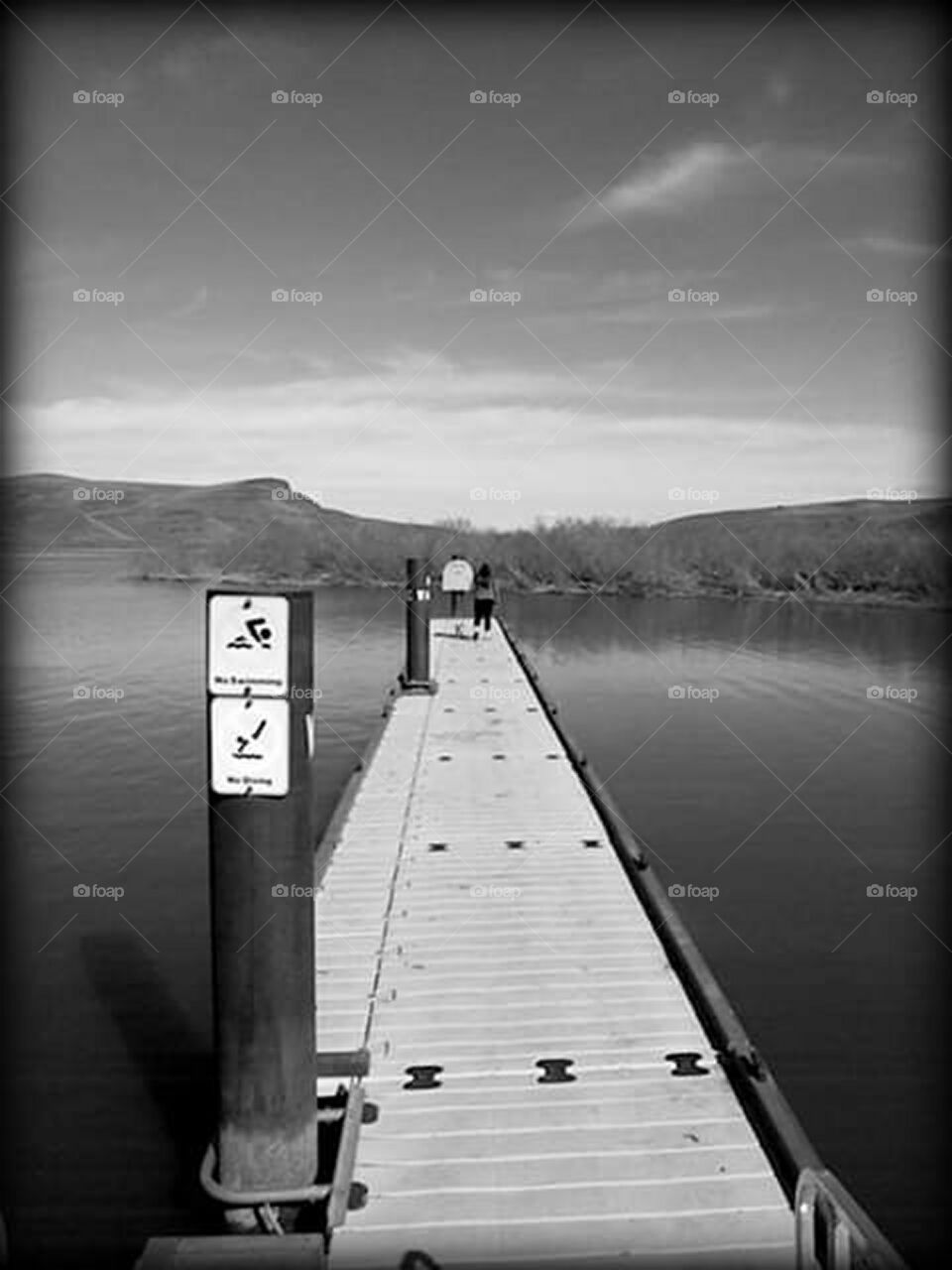 black and white scene of boat dock on lake