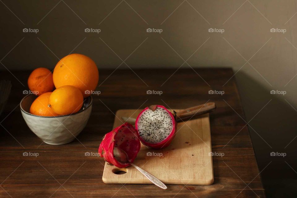 Fruit - oranges and dragon fruit on the table in the kitchen
