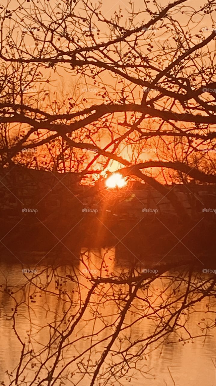 Evening Sunset high clouds spreading the sunbeams with the clouds. Evening colors appear strong for this early pic. Reflections of the Sunbeams / Rays off the lake waters.