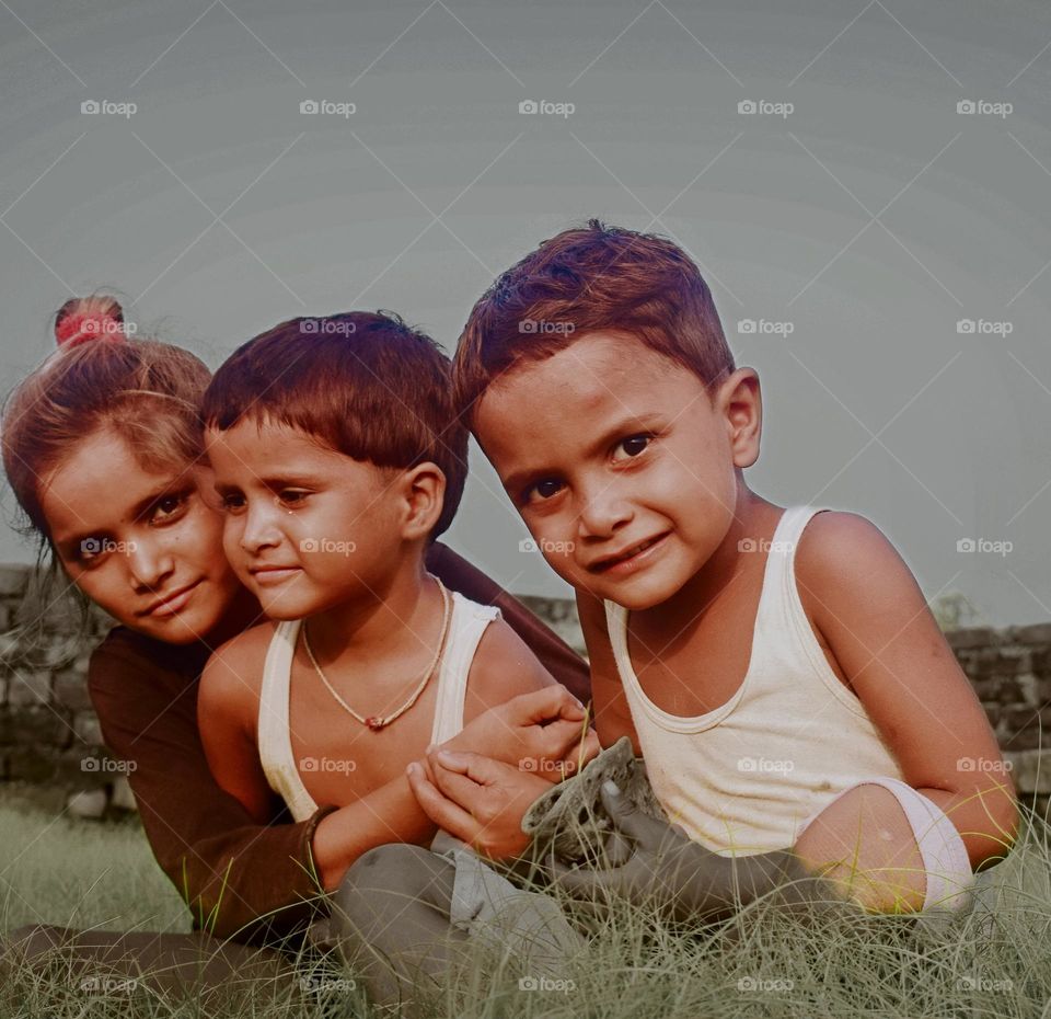 three children sitting in the field