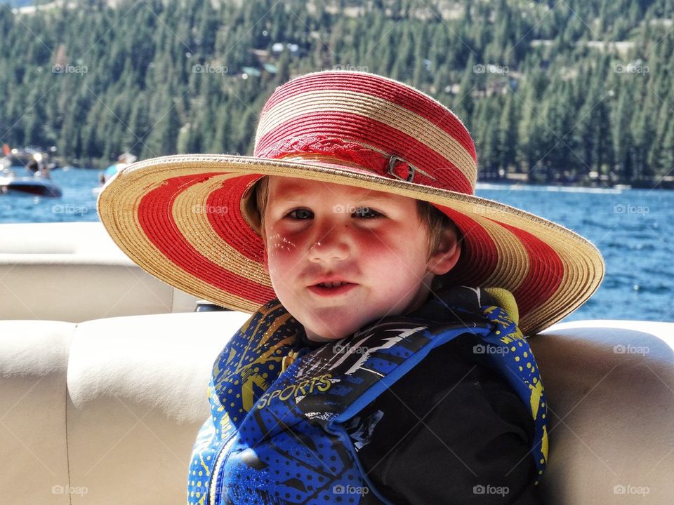 Preventing Sunburn. Young Boy Wearing A Sun Hat On A Boat
