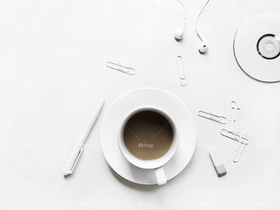 Coffee cup and office supplies on white desktop 