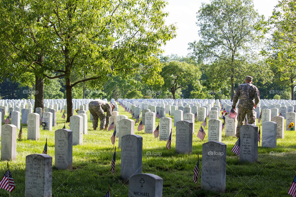 Soldiers plant flags on the nearly 400,000 graves at Arlington National Cemetery to commemorate Memorial Day. Arlington, VA