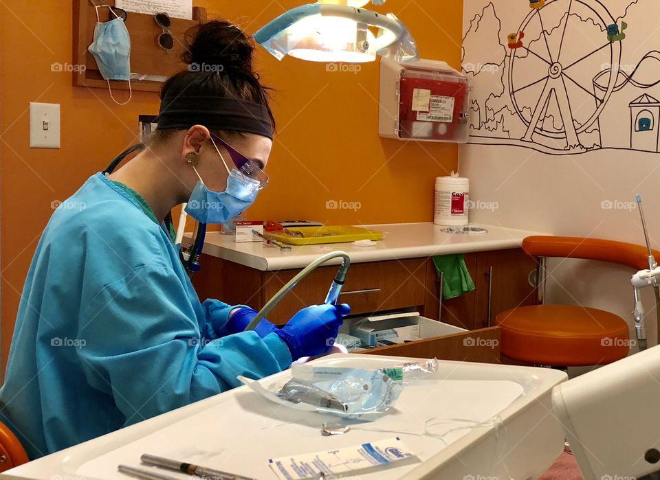 Dentist, dental, hygienist, hygiene, dental hygienist,dental hygiene, tools, teeth, tooth, cleaning, tray, mask, woman, female, gloves, blue, orange, counter, light, brunette, dentist office, office, exam, examination, dental exam, patient, medicine 