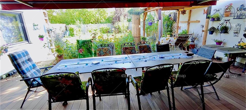 This is the table for a big birthday banquet in “Straubing”, “Lower Bavaria”, Germany. Through a large sliding glass door we look upon the lush green garden outside. 2024. Hypnotic Productions