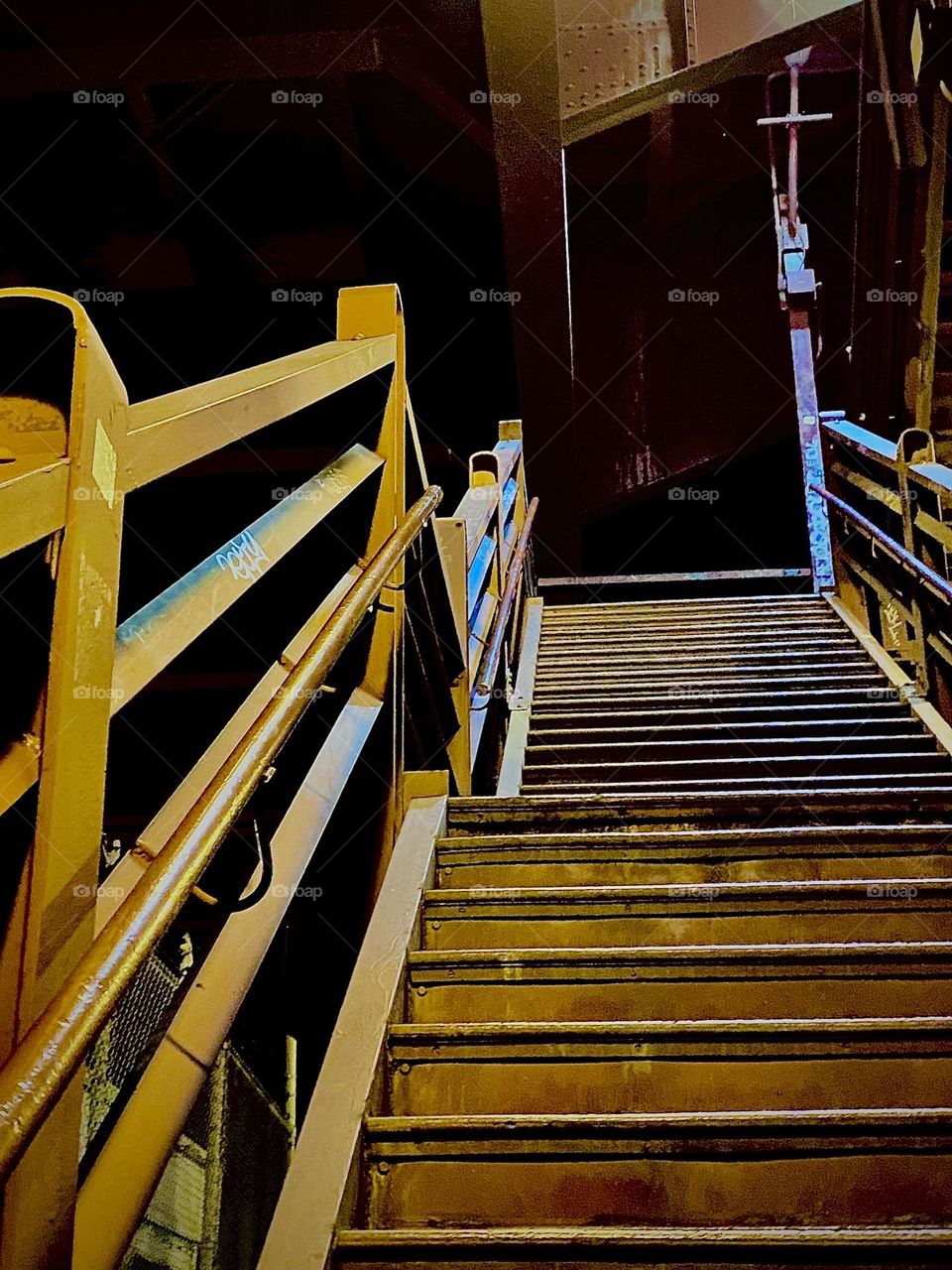 The staircase leading up to the “Pulaski Bridge” pedestrian overpass photographed as I am ascending from the “Greenpoint”, Bklyn side on an evening in early October 2022. Hypnotic Productions