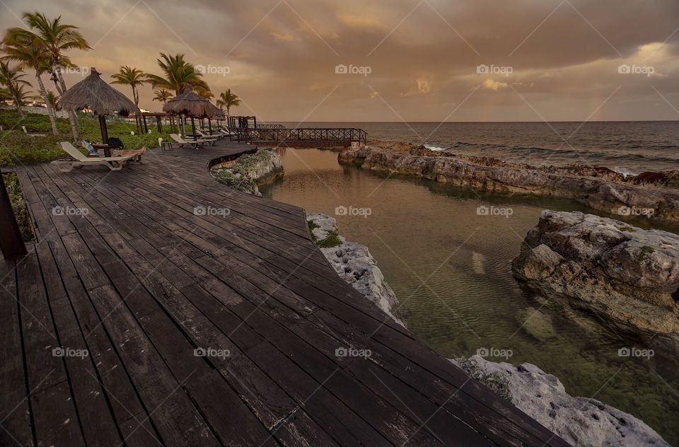 Wooden pier overlooking the sea at dusk: The view of a balnerae establishment in Puerto AVenturas in Mexico