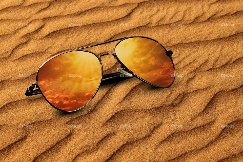 Desert sand and clouds reflection on sunglasses -  vacation concept