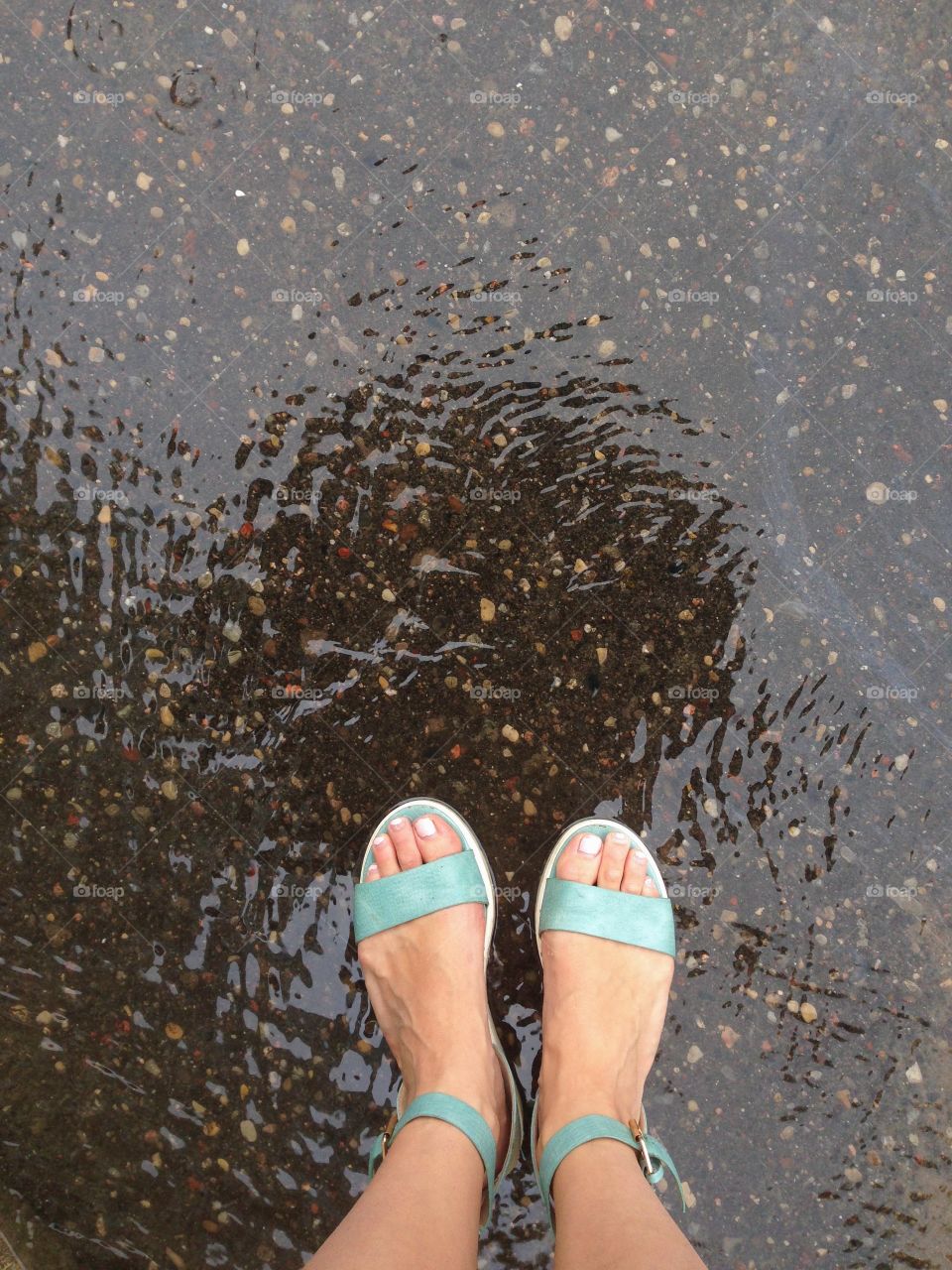 Feet standing in a puddle after rain 