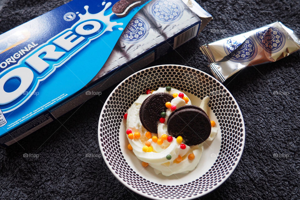 Oreo cookies with whipped cream and sprinkles.