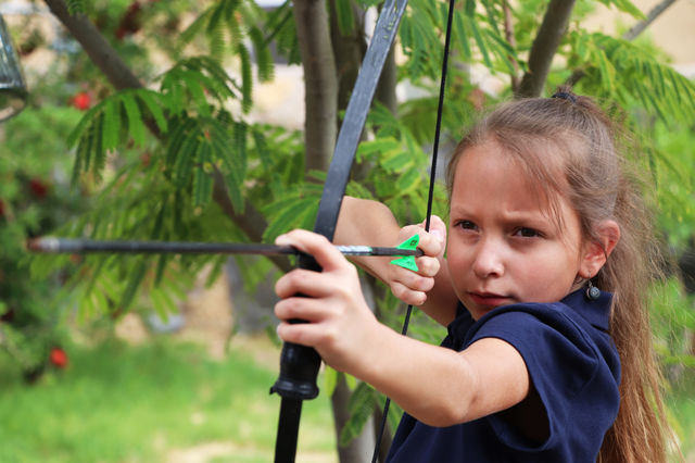 Child shooting bow and arrow