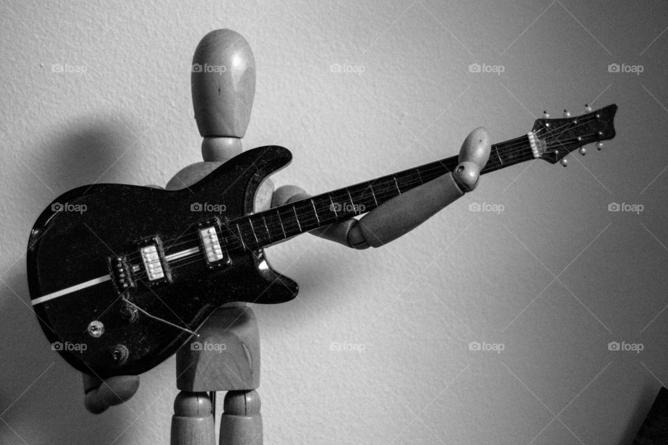 articulated doll playing an electric guitar