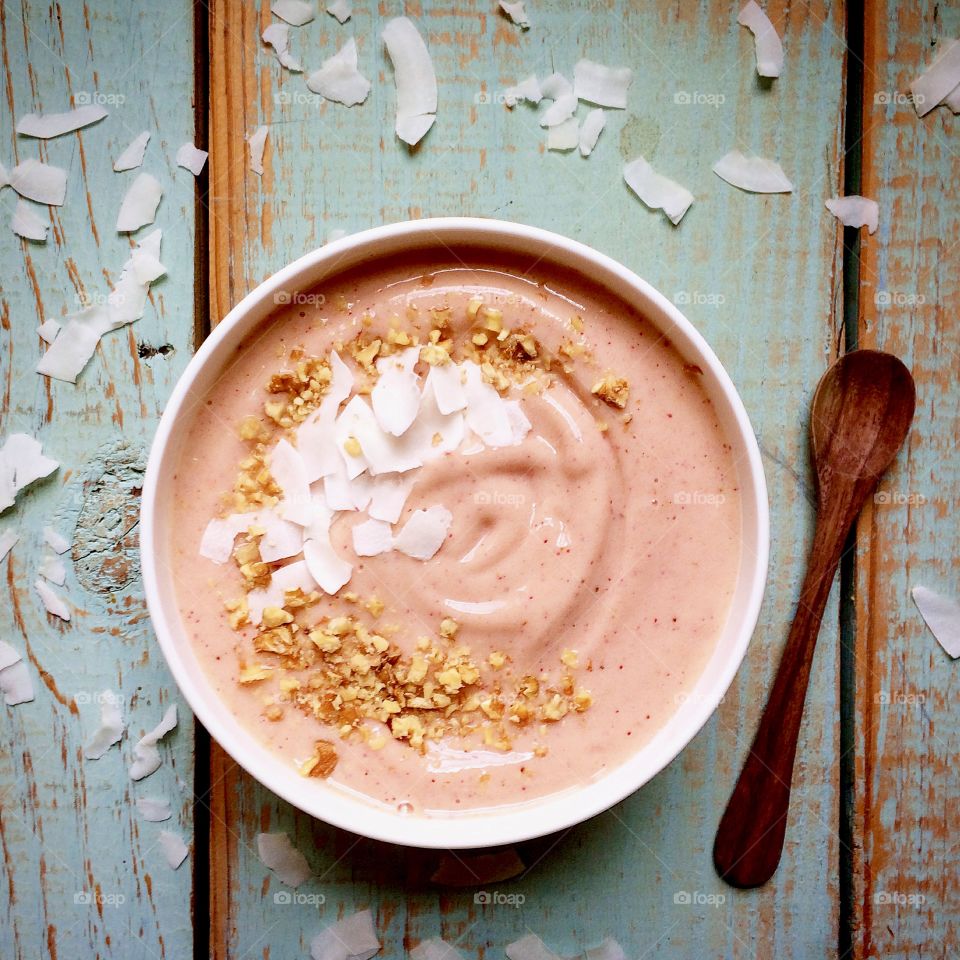 Smoothie bowl with crushed walnuts and coconut flakes. 