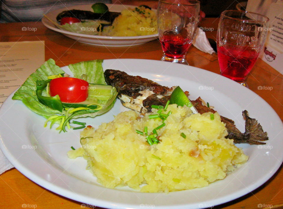 Food on a plate. fried fish trout with potatoes and salad