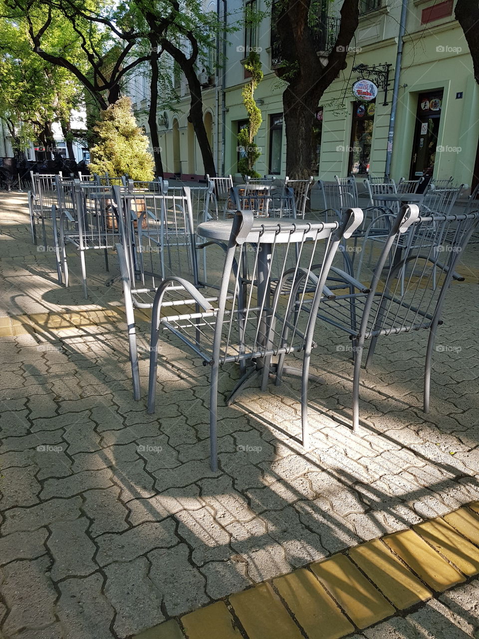 restaurant terrace with empty iron tables and chairs