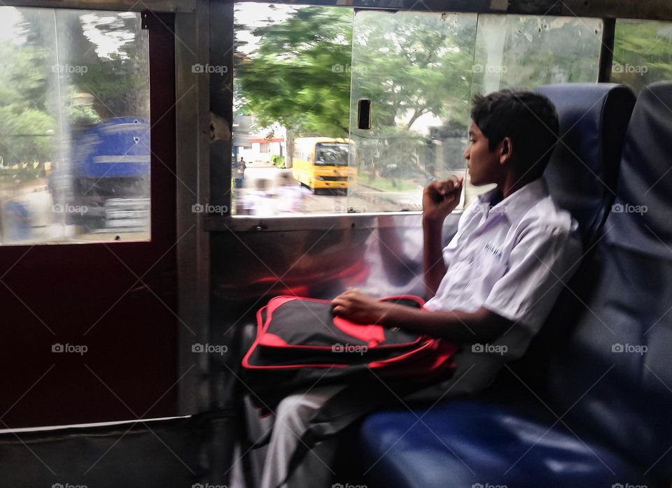 A boy commuting to school in a public transport 