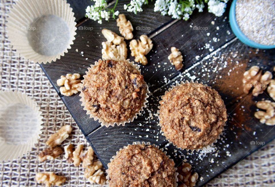 Healthy homemade oat bran muffins with walnuts on a dark wood board