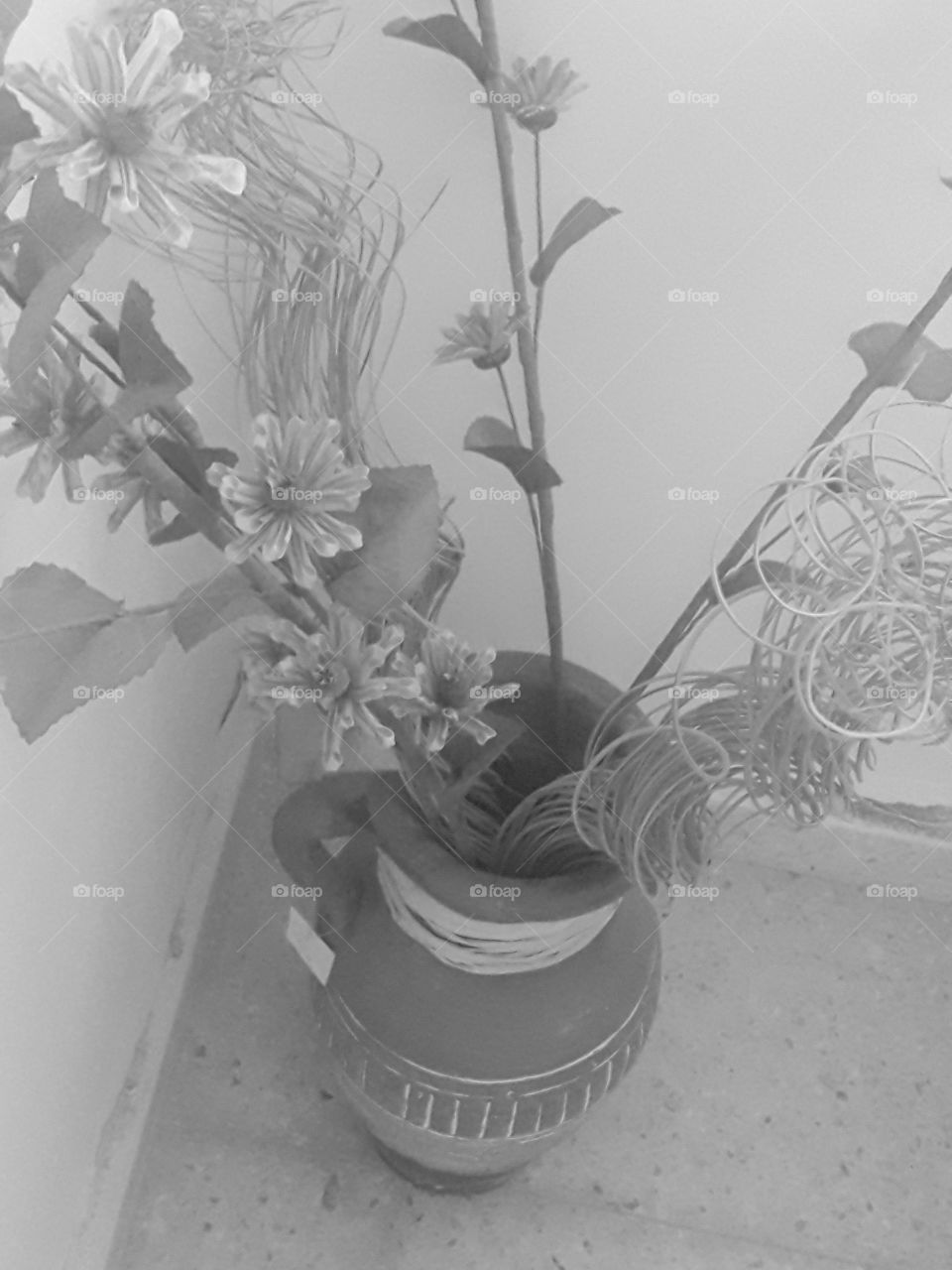 black and white picture with vase and dry flower