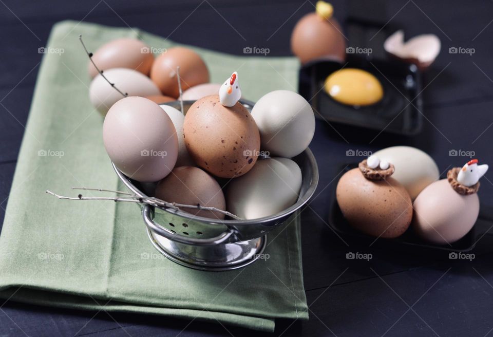 A cute fresh egg scene with toy chickens and eggs on a black backboard