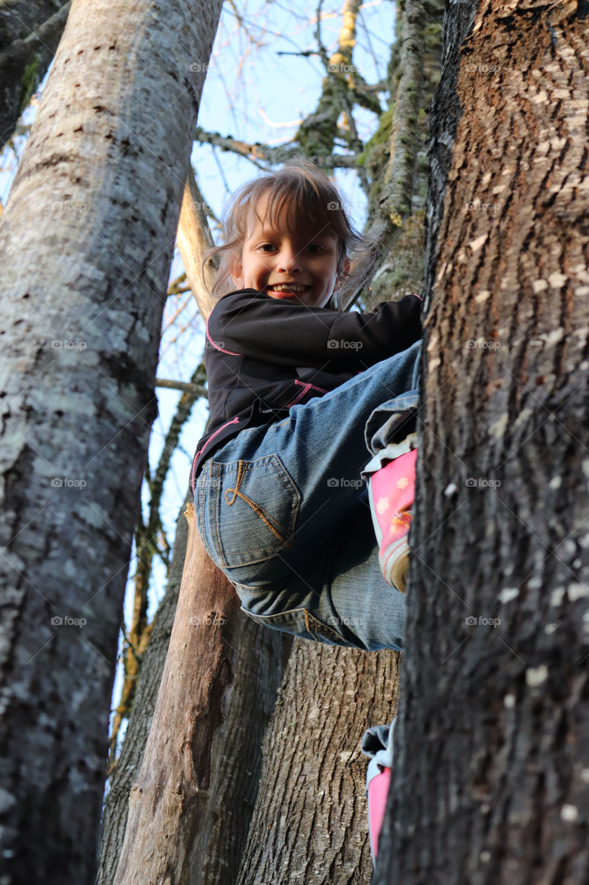 Girl climbing up a tree