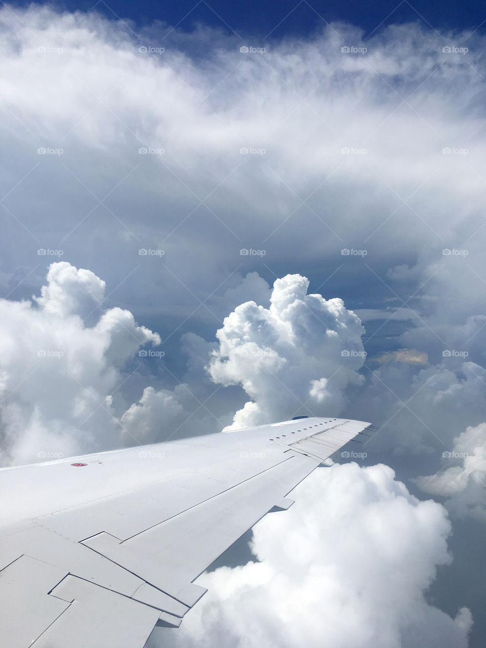 Airplane flying around storm clouds window view of wing