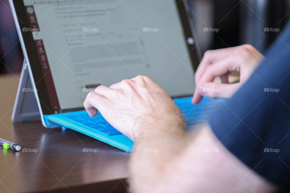 A person typing on a portable computer keybord