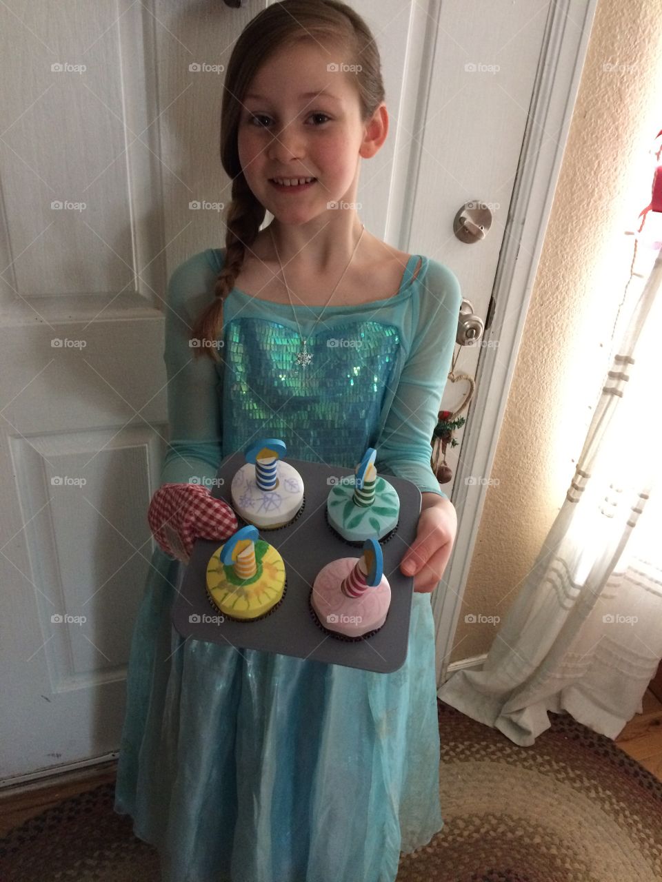 Smiling girl holding with tray of cakes