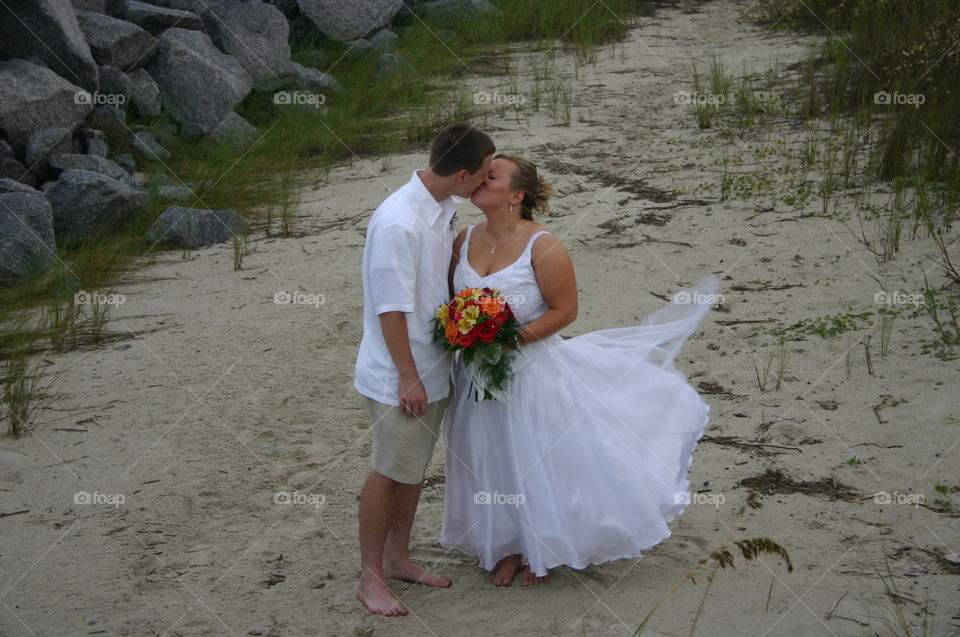 Newly Wed kiss. I was photographing this wedding and asked couple to kiss, just as they kissed the wind blew her dress