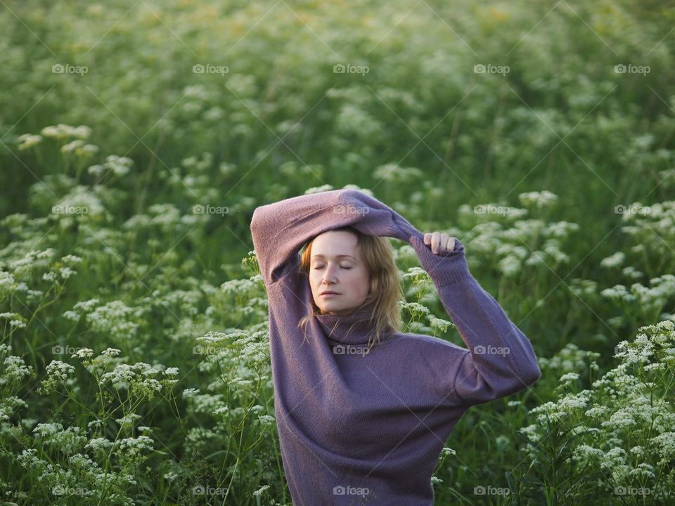 Portrait of young beautiful woman in the blooming field 