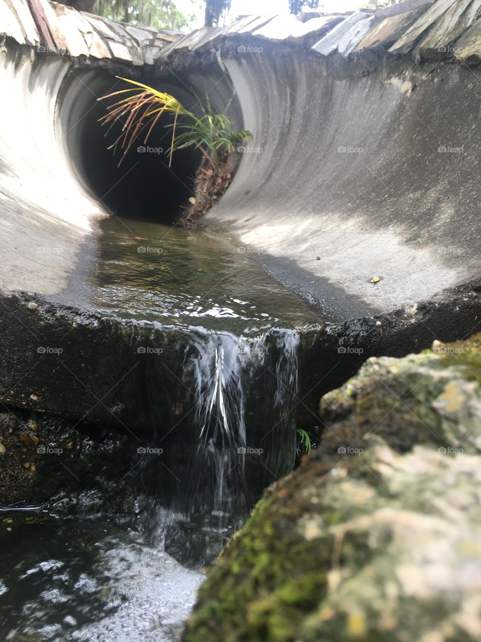 Water running through a pipe outdoors 