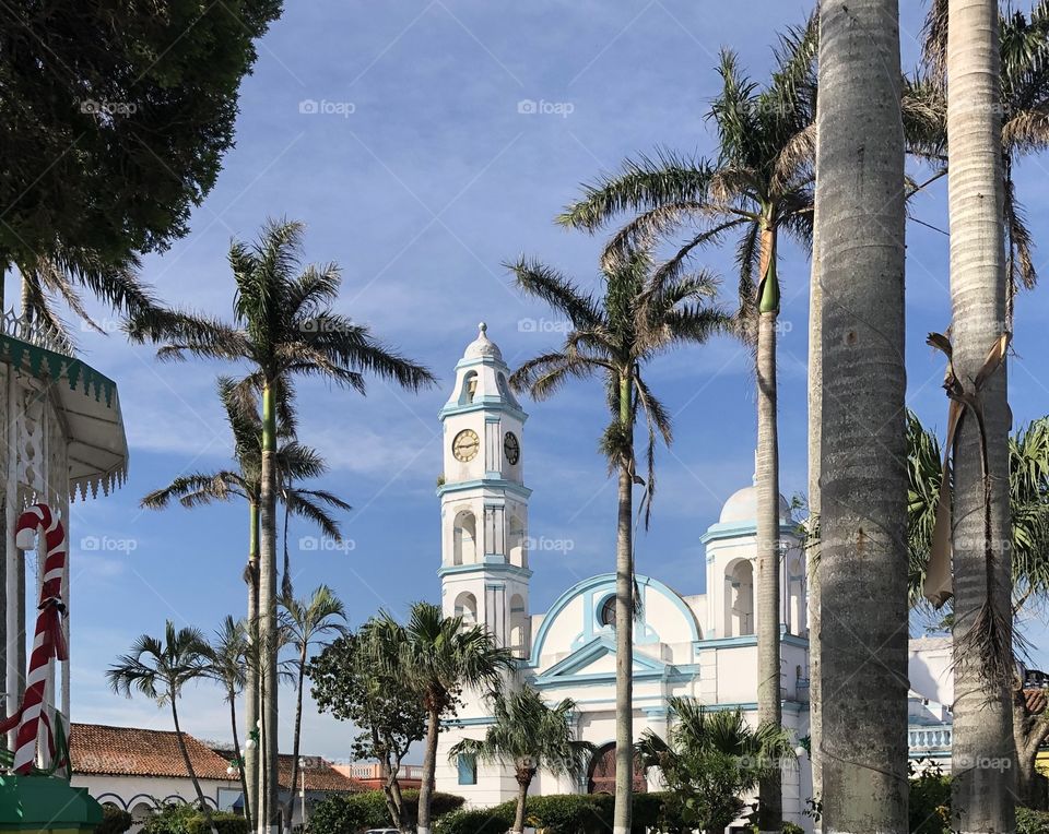 A beautiful picture of a city called Tlacotalpan in Mexico. The palm trees sway and the clouds slowly pass by as the sun shines all throughout the city. 