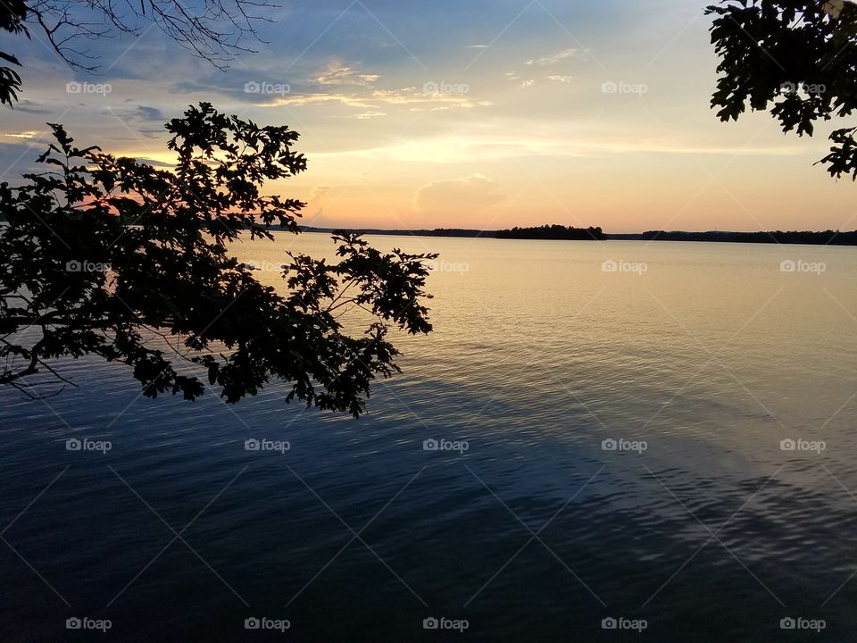 sun setting over lake