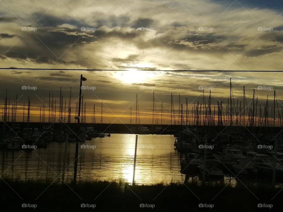 Sun rise in Badalona's harbour after a stormy night.