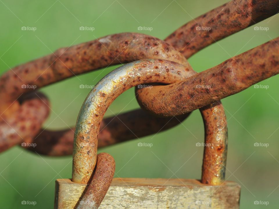 Rusty padlock on iron chain