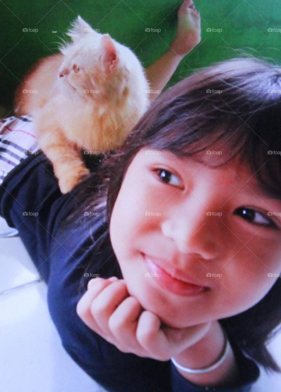 The cat is very spoiled with its owner and children. The girl loves her pet cat so much that they look familiar