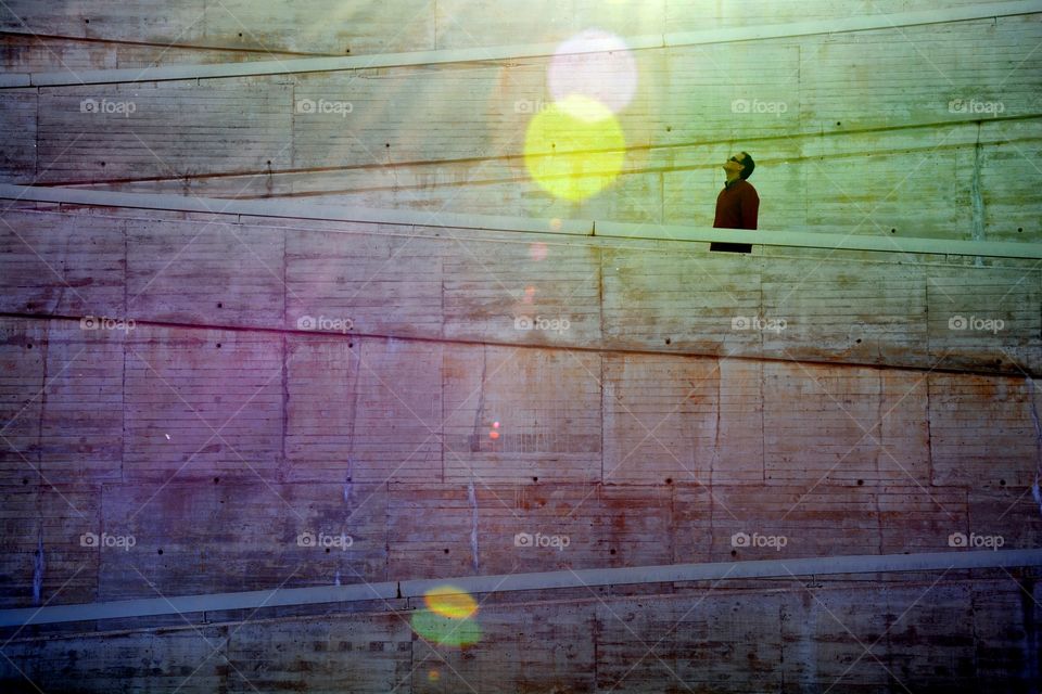 a man in a wall looking up, watching the sun