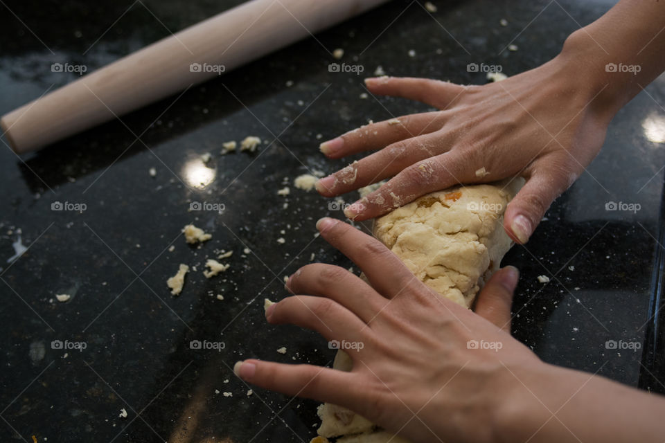 A woman is in the kitchen baking and cooking homemade scones with fruit and fresh herbs