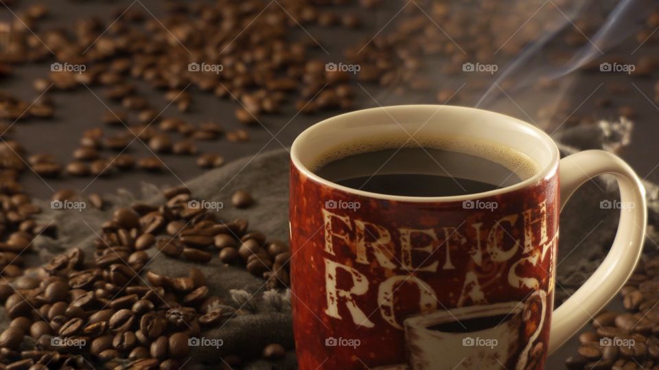 Steaming hot coffee with coffee beans