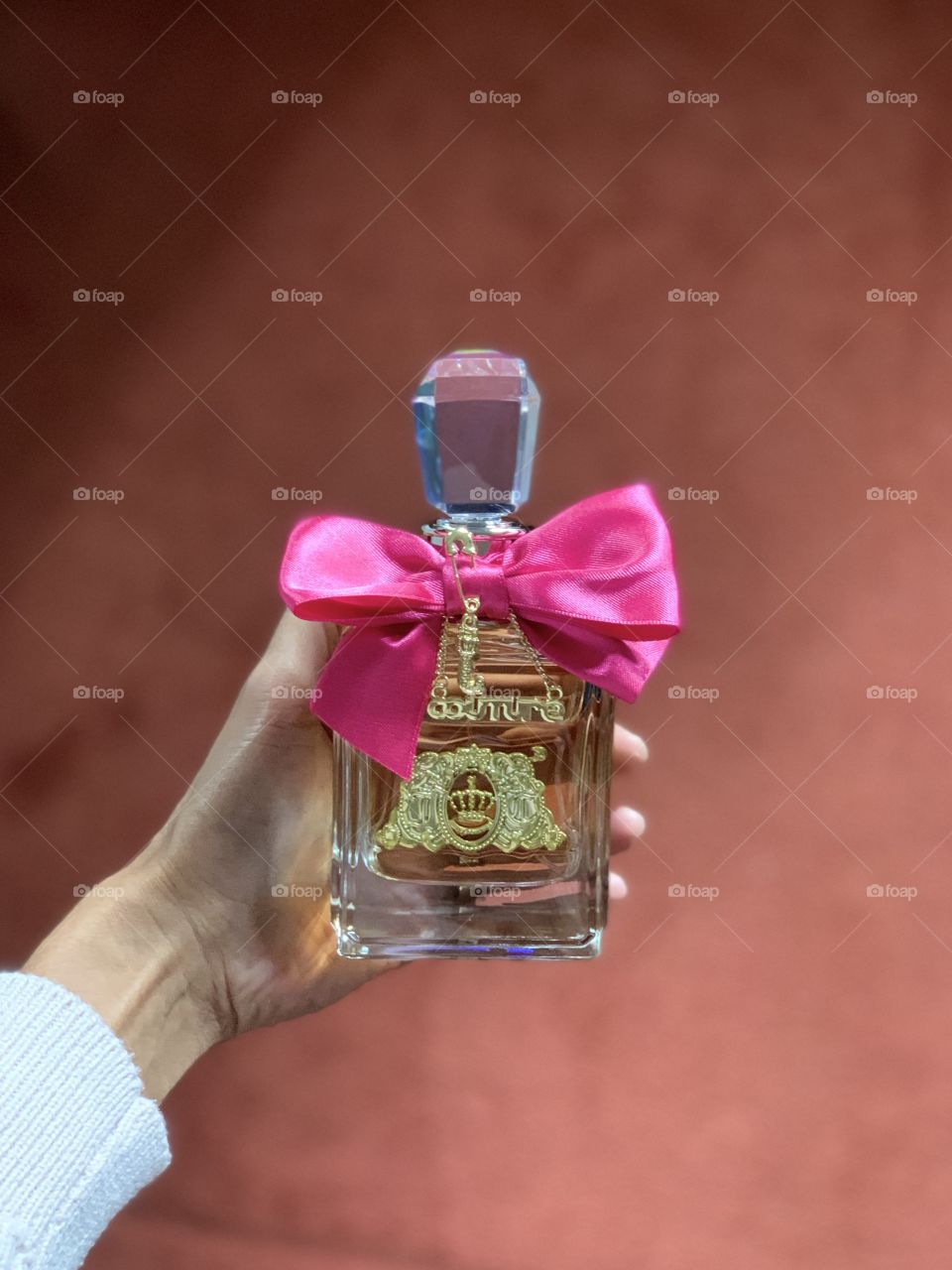 A woman holding a Viva La Juicy Perfume