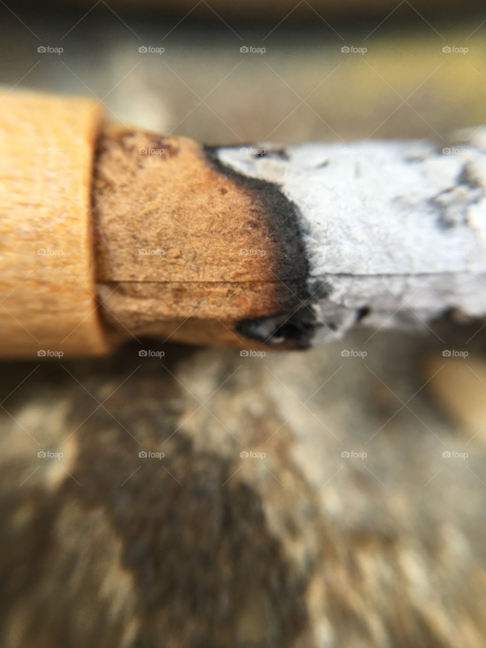 Wood tipped burning cigar. 