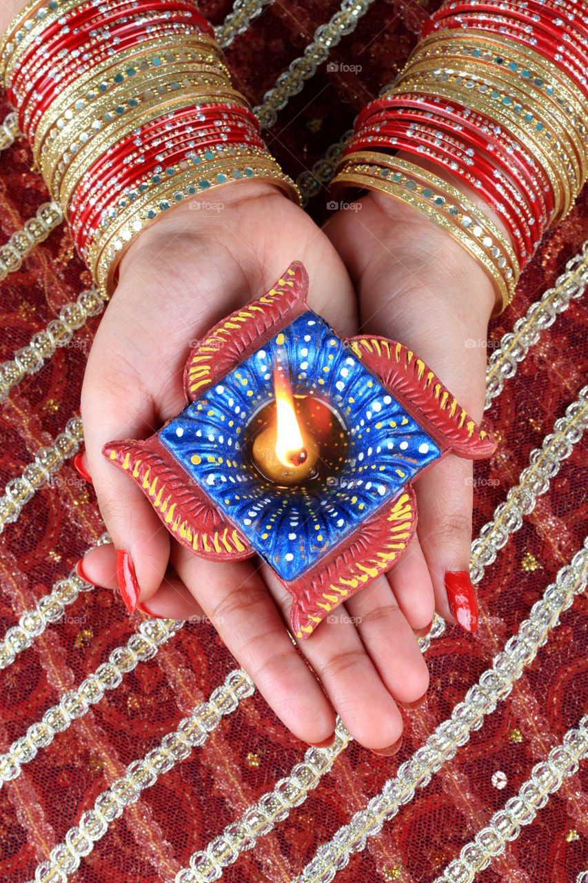 Beautiful Diwali diya oil lamp in a female's hand